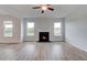 Bright living room featuring a fireplace, ceiling fan, and windows at 119 Felicity Pike, Locust Grove, GA 30248