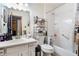 Bright bathroom featuring a white vanity, toilet, and shower-tub combination with shelving at 1292 Marcelle Heights Nw Pl, Norcross, GA 30093