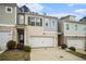 Attractive townhome boasts a neutral color palette, a one-car garage, and a welcoming driveway at 1868 Fabian Way, Austell, GA 30106