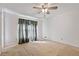A bright bedroom is illuminated by a ceiling fan and a large window with curtains at 2340 Castleridge Ct, Tucker, GA 30084