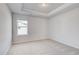 Bright bedroom with neutral carpet, tray ceiling, and a window that provides natural light at 115 Felicity Pike, Locust Grove, GA 30248
