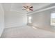 Spacious bedroom featuring plush carpeting, tray ceiling with fan, and large windows for ample lighting at 115 Felicity Pike, Locust Grove, GA 30248