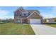 Beautiful two-story brick home with a two-car garage and a well-manicured lawn on a sunny day at 115 Felicity Pike, Locust Grove, GA 30248