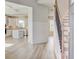 Bright foyer featuring hardwood floors, decorative staircase, and an open view to the kitchen and dining area at 115 Felicity Pike, Locust Grove, GA 30248