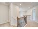 Second floor hallway with carpeted floors, wood and iron railing, and access to rooms at 115 Felicity Pike, Locust Grove, GA 30248