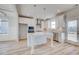 Modern kitchen featuring white cabinets, an island with seating, stainless steel appliances, and wood floors at 115 Felicity Pike, Locust Grove, GA 30248