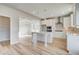 Modern kitchen featuring white cabinets, an island with seating, stainless steel appliances, and wood floors at 115 Felicity Pike, Locust Grove, GA 30248
