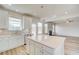 Bright kitchen features an island with quartz countertop, white cabinets and stainless steel dishwasher at 115 Felicity Pike, Locust Grove, GA 30248