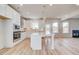 Modern kitchen featuring white cabinets, an island with seating, stainless steel appliances, and wood floors at 115 Felicity Pike, Locust Grove, GA 30248