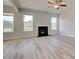 Spacious living room with fireplace, ceiling fan, light gray walls and luxury vinyl flooring at 115 Felicity Pike, Locust Grove, GA 30248