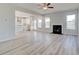 Bright living room with luxury vinyl flooring, fireplace and an open plan to the kitchen at 115 Felicity Pike, Locust Grove, GA 30248
