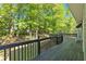 Wooden back deck with black railing and a lush tree view at 27 Friendship Rd, Euharlee, GA 30145