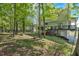 A spacious backyard featuring mature trees and a deck accessible from the upper level of the light green two-story house at 27 Friendship Rd, Euharlee, GA 30145