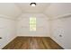 Finished attic with wood-look floors, window, storage racks, and two closet doors at 3239 Rose Petal Ln, Powder Springs, GA 30127