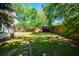 Spacious backyard featuring lush green grass, mature trees, and a wooden privacy fence at 3239 Rose Petal Ln, Powder Springs, GA 30127