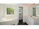 Bright bathroom with a soaking tub under a window and marble-patterned floor at 3239 Rose Petal Ln, Powder Springs, GA 30127