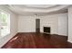 Bedroom featuring a fireplace, hardwood flooring, and a tray ceiling at 3239 Rose Petal Ln, Powder Springs, GA 30127