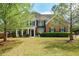 Beautiful two-story brick home with a large front lawn and mature trees at 3239 Rose Petal Ln, Powder Springs, GA 30127