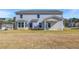 Back exterior of home showcasing the covered patio, lush lawn, and a beautifully landscaped yard at 123 Felicity Pike, Locust Grove, GA 30248
