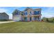 Charming two-story home featuring brick and gray siding, a lush green lawn, and a double garage at 123 Felicity Pike, Locust Grove, GA 30248