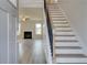 Welcoming foyer with wood-look floors, staircase, and a view into the light-filled living room at 123 Felicity Pike, Locust Grove, GA 30248