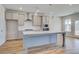 Bright kitchen featuring stainless steel appliances, gray cabinets, an island and light wood-look flooring at 123 Felicity Pike, Locust Grove, GA 30248