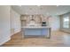 Bright kitchen featuring stainless steel appliances, gray cabinets, an island and light wood-look flooring at 123 Felicity Pike, Locust Grove, GA 30248