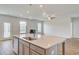 Open concept living room with large island, fireplace, and ceiling fan with plenty of natural light at 123 Felicity Pike, Locust Grove, GA 30248