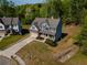 An aerial view of a charming two-story home with a well-manicured lawn and long driveway in a wooded neighborhood at 19 Four Feathers Ne Ln, Rydal, GA 30171