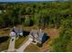 Overhead shot of a well-kept home with green lawns, set within a lush, tree-filled area, in a beautiful neighborhood at 19 Four Feathers Ne Ln, Rydal, GA 30171