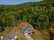 Aerial shot of a home nestled in a lush, green forest, with a long driveway leading to the charming property at 19 Four Feathers Ne Ln, Rydal, GA 30171