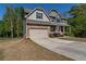 Charming home boasts a two-car garage, a front porch, and a well-manicured lawn at 19 Four Feathers Ne Ln, Rydal, GA 30171
