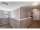 Upstairs hallway with neutral paint, carpet, window, and views into adjacent rooms, creating a functional and connected living space at 19 Four Feathers Ne Ln, Rydal, GA 30171