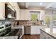 Modern kitchen with stainless appliances, granite counters, and a view of the backyard at 19 Four Feathers Ne Ln, Rydal, GA 30171