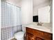 Bathroom with a wood vanity, shower with blue-patterned curtain, toilet, and white walls at 4689 Shire Dr, Lithonia, GA 30038