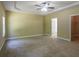 Large main bedroom with tray ceiling, carpet, and doorways to closet and bath at 1544 English Manor Cir, Stone Mountain, GA 30087