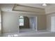 Large main bedroom with tray ceiling, carpet, and a doorway to an additional room at 1544 English Manor Cir, Stone Mountain, GA 30087