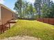 A fenced backyard showing off a spacious yard with a gentle slope and steps leading to a lower patio at 1704 Golf Link Dr, Stone Mountain, GA 30088