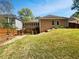 Spacious backyard with a fenced perimeter, showcasing a large lawn area and a deck for outdoor entertainment at 1704 Golf Link Dr, Stone Mountain, GA 30088