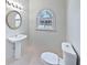 This half bathroom has a pedestal sink, toilet and window at 1704 Golf Link Dr, Stone Mountain, GA 30088