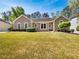 Charming single-story home with a well-manicured lawn, green shrubbery, and a welcoming facade at 1704 Golf Link Dr, Stone Mountain, GA 30088