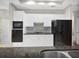 Modern kitchen featuring white cabinets, black appliances, granite countertops, and tile backsplash at 1704 Golf Link Dr, Stone Mountain, GA 30088