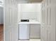 Dedicated laundry room with washer, dryer, and overhead shelving at 1704 Golf Link Dr, Stone Mountain, GA 30088