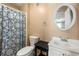 Cozy bathroom features a shower with patterned curtain, toilet, and vanity with oval mirror at 3923 Lookout Point Dr, Marietta, GA 30066