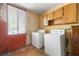 Laundry room with washer, dryer, window and upper wood cabinets for storage at 3923 Lookout Point Dr, Marietta, GA 30066