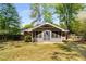 Rear view of house and screened in porch with mature trees and grass at 404 Bridlewood Cir, Decatur, GA 30030