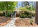 Charming brick home with a stone walkway and mature trees creating a welcoming curb appeal at 404 Bridlewood Cir, Decatur, GA 30030