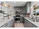 Well-equipped kitchen with gray cabinets, stone countertops, and stainless steel appliances at 404 Bridlewood Cir, Decatur, GA 30030