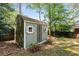 Garden shed featuring painted siding, a shingled roof, and small white framed windows at 404 Bridlewood Cir, Decatur, GA 30030