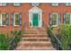 Inviting brick steps leading to a bright green front door, framed by symmetrical landscaping and black shutters at 5251 Amberbrook Ct, Marietta, GA 30068